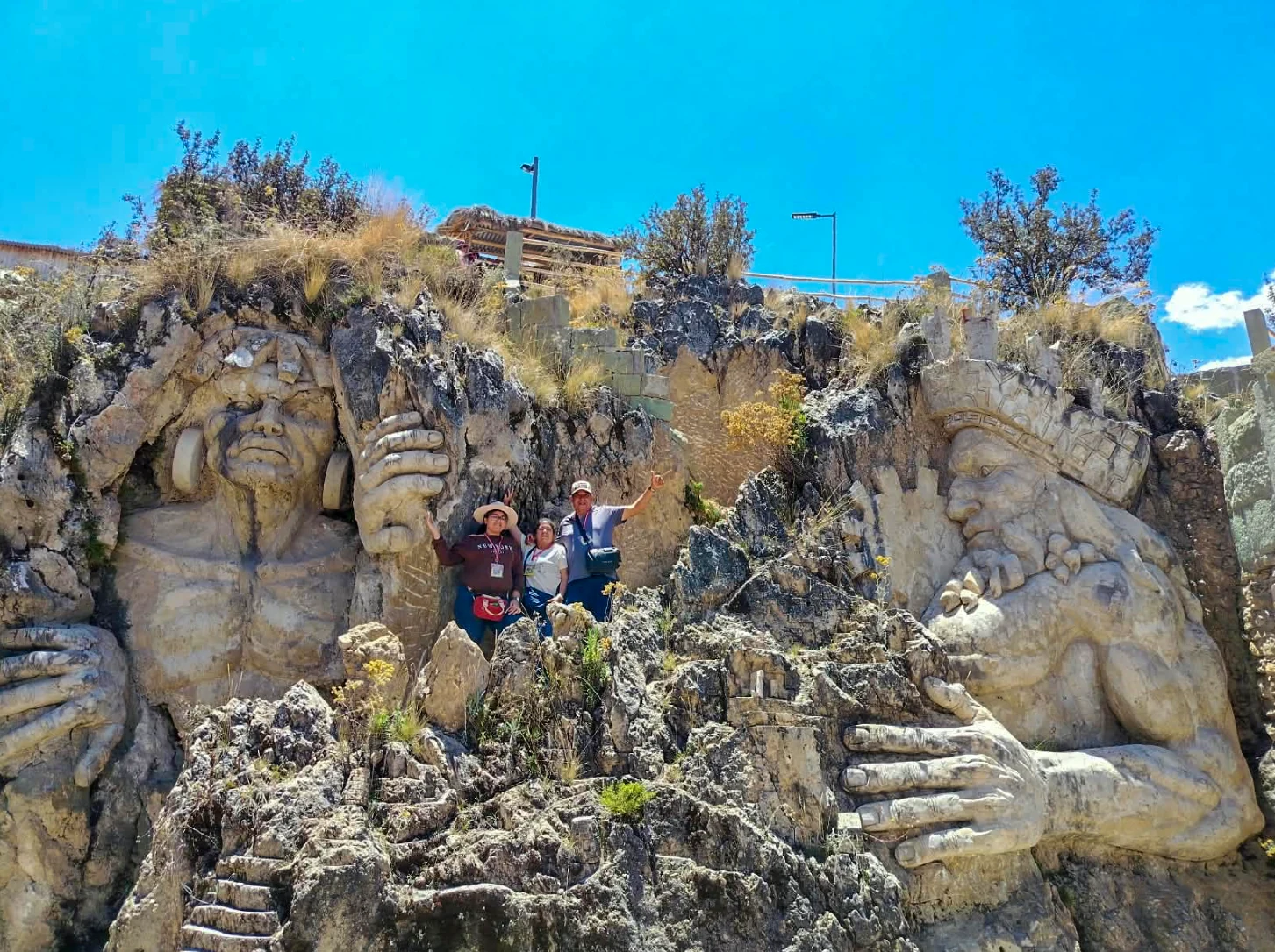 Tres viajeros entre las esculturas de piedra de la Morada de los Dioses en Cusco