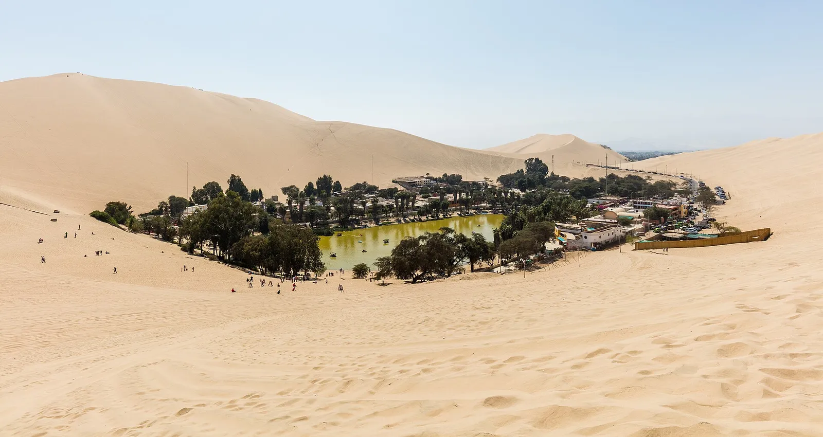 Laguna y vegetación del oasis de Huacachina entre las dunas de Ica