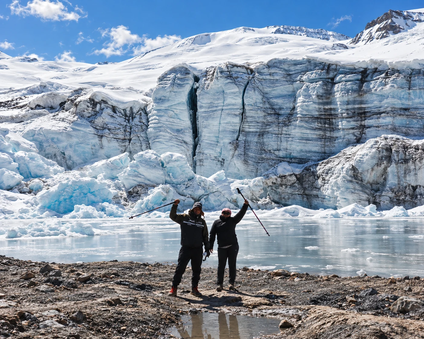 Dos viajeros frente al glaciar Quelccaya y una laguna al pie del hielo